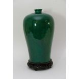 A large Chinese green glazed Meiping vase on wooden stand, reign mark to base..Approximately 40cm