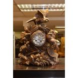 A black forest clock carved with rabbits and birds