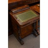 A Victorian walnut davenport with ebony cross banding with a hinged top and flight of drawers to the