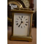 A brass case carriage clock, the enamel dial with