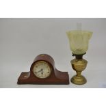 An oak mantle clock and oil lamp
