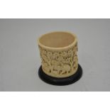 A Chinese carved ivory brushpot showing a procession of figures and animals.Approximately 8.5 cm