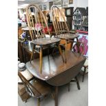 A dark wood Ercol dining table and four chairs plus a conforming sideboard and plate rack