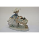 A Lladro model of a girl pushing puppies in a whee