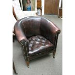 A leather tub chair with button seat on caster fee