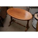 A Victorian oval side table with fluted legs, united by a stretcher