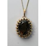 A 9ct gold smoked quartz pendant and chain