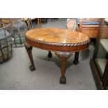 A Walnut occasional table the oval top with a gadrooned edge on cabriol legs and ball and claw