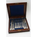 A mahogany case containing silver plated fruit knives and forks