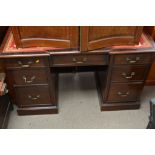 Victorian style desk with red leather top above nine drawers on plinth base.