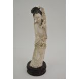 A similar smaller carved ivory figure on wooden ba