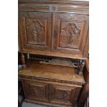 A 19th Century French cabinet, the cupboard doors profusely carved with raised figures on bulbous