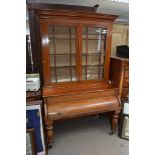 A Victorian mahogany piano bookcase, the glazed doors above a roll top on turned legs