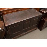 An 18th Century oak coffer the hinged lid above a paneled front