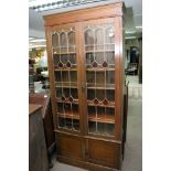 An Oak bookcase with lead light glazed panels, and cupboard under.