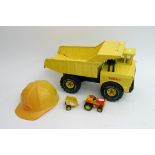 An unboxed Tonka toys tipper lorry together with a small Tonka toys tractor and cart and a yellow