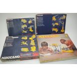 Four boxed Meccano sets.