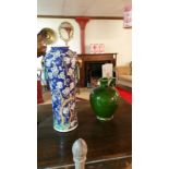 Two pottery vases, one a green studio flagon, glazed, the other a chinese style vase with link