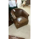 Chestnut brown leather tub chair. Stud detail to arms with stained beech turned legs to front and