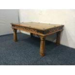 Rustic wood coffee table with carved pelmet detail and decorative ironwork detail.