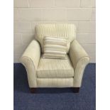 20th C armchair in good quality cream self-stripe fabric and a contrast cushion. Castors.