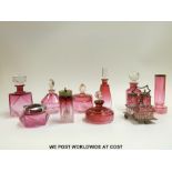 A collection of cranberry glass to include seven faceted scent bottles and powder pots,