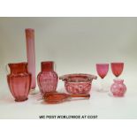A collection of cranberry glass to include an enamelled vase, a Mary Gregory vase,