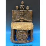 A Chokwe Chief's chair carved with typical Chokwe faces and figures with hide and stud decoration