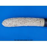 A Balinese ivory knife with ornately carved figural handle and white metal collar (36cm long)