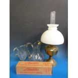 An oil lamp with glass shade and two large glass jugs