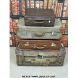 Four vintage leather and canvas suitcases, some with original shipping labels.