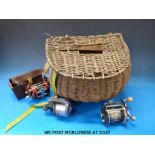 Vintage wicker fishing creel with Abu & Penn multipliers and an Abu closed faced reel.