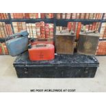 A metal trunk with vintage petrol cans