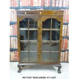 A glazed late 19th / 20th bookcase raised on ball and claw feet (W82 x D26 x H122cm)