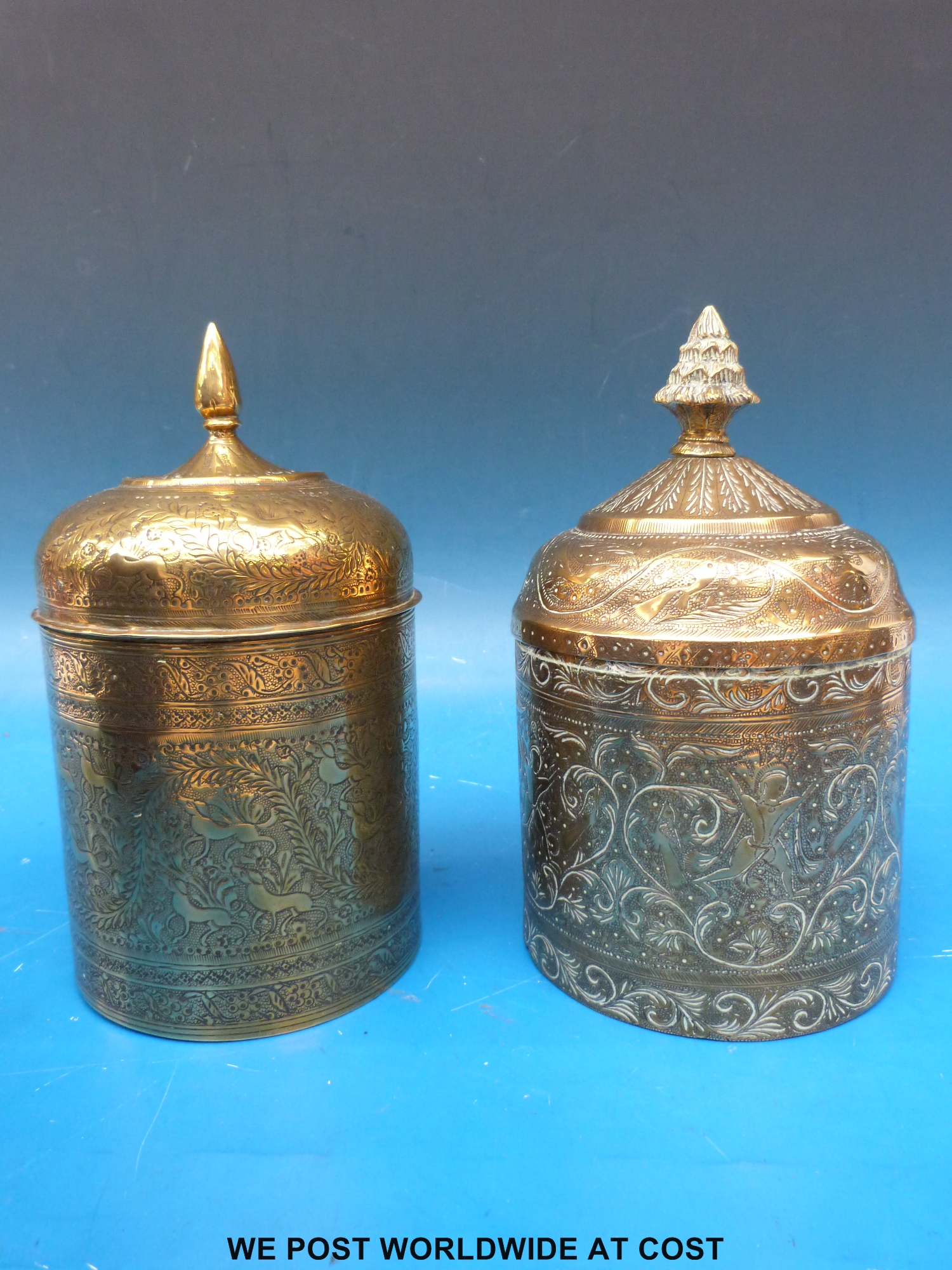 Two late 19th/20thC engraved brass lidded caddies of Indian or Persian origin (21cm tall)