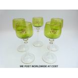 A set of ten hock glasses with green bowls monogrammed with the letter 'H' and gilt rims raised on