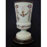 An opaline glass vase decorated in enamels with butterflies amongst floral swags on pedestal base