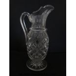 A large clear glass ewer with applied handle,