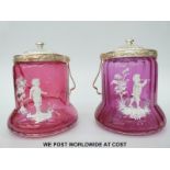 A pair of Mary Gregory cranberry glass biscuit barrels with silver plated rims and handles and