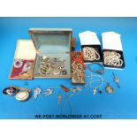 A quantity of costume jewellery to include an amber brooch, marcasite brooches, enamel buttons,