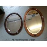 Two oval oak framed mirrors, both with bevelled glass,