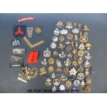 Over 50 military cap badges from WWI onwards, cloth examples,