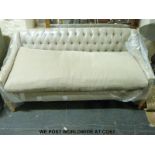 A two seat sofa with button back design