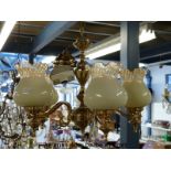 A contemporary five branch brass lamp fitting with glass shades with a pair of matching wall lights,