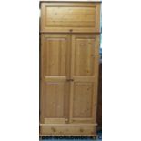 A pine wardrobe with cupboard above and drawer below (W95 D58 H219cm)