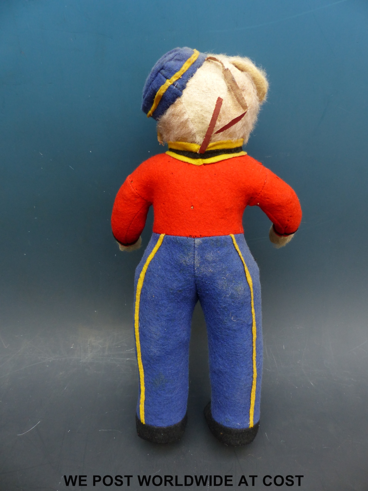 A straw filled teddy bear in red, blue and yellow railway uniform with matching hat, 35cm tall. - Image 2 of 3