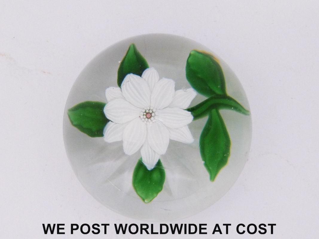 Baccarat clematis glass paperweight, the central flower with white petals and green leaves and stem,
