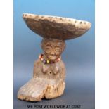 An African figural tribal stool with a kneeling female figure balancing the seat on her head (28cm