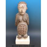 An African tribal maternity figure of a pregnant woman on stone plinth (51cm tall)