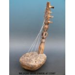 African tribal bow harp, the shaft carved with a figure and the base covered in animal hide,